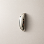 Polished chrome curved handle on a plain light surface.
