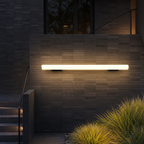 Glowing horizontal wall light mounted on a dark tiled exterior wall.