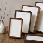 Rounded wooden picture frames with white mats arranged on a wooden tabletop.