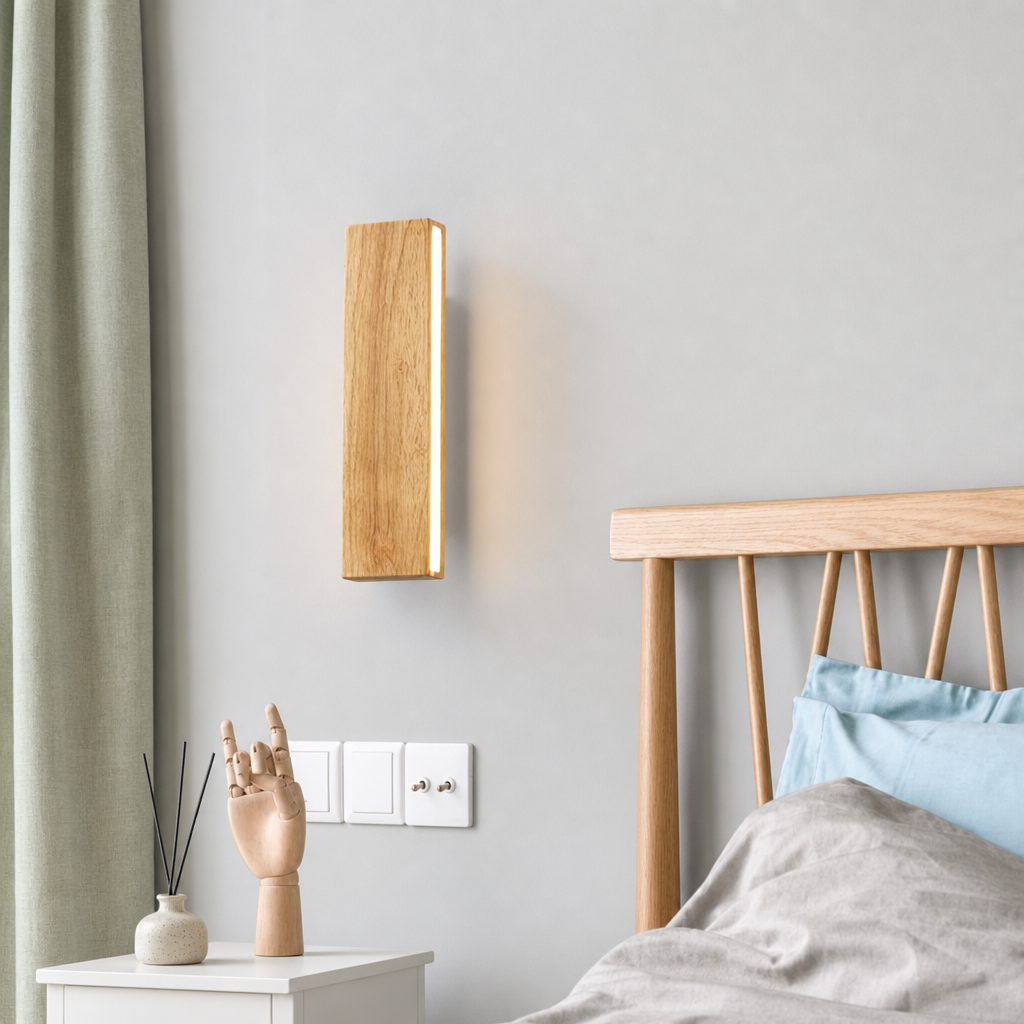 Wooden wall sconce glowing warmly beside a bed in a minimalist bedroom.