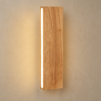 Wooden wall sconce with a vertical warm LED strip on a neutral wall.
