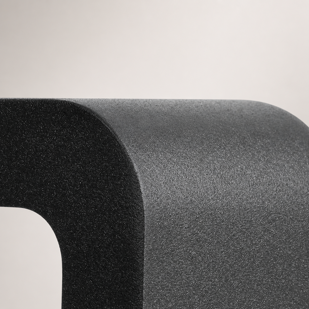 Close-up of a rounded dark gray textured product corner on a pale gray background.