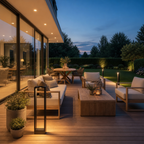 Modern black outdoor bollard light glowing on a wooden patio beside lounge seating.