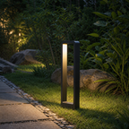 Modern black rectangular garden path light glowing warmly beside a stone walkway.