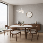 Round white dining table with walnut chairs and cushions in a bright modern dining room.