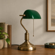 Green banker’s desk lamp on a wooden desk