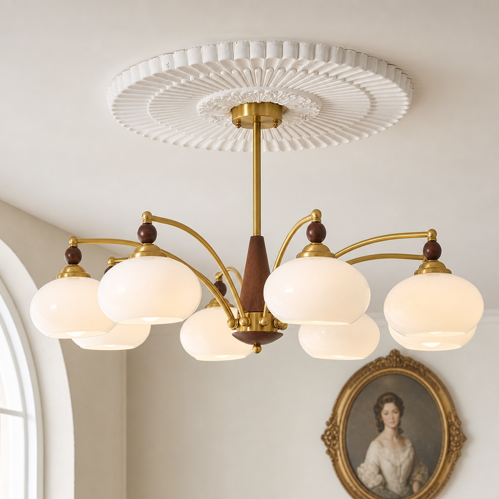 Brass and wood chandelier with six glowing white glass globes under a white ceiling medallion.