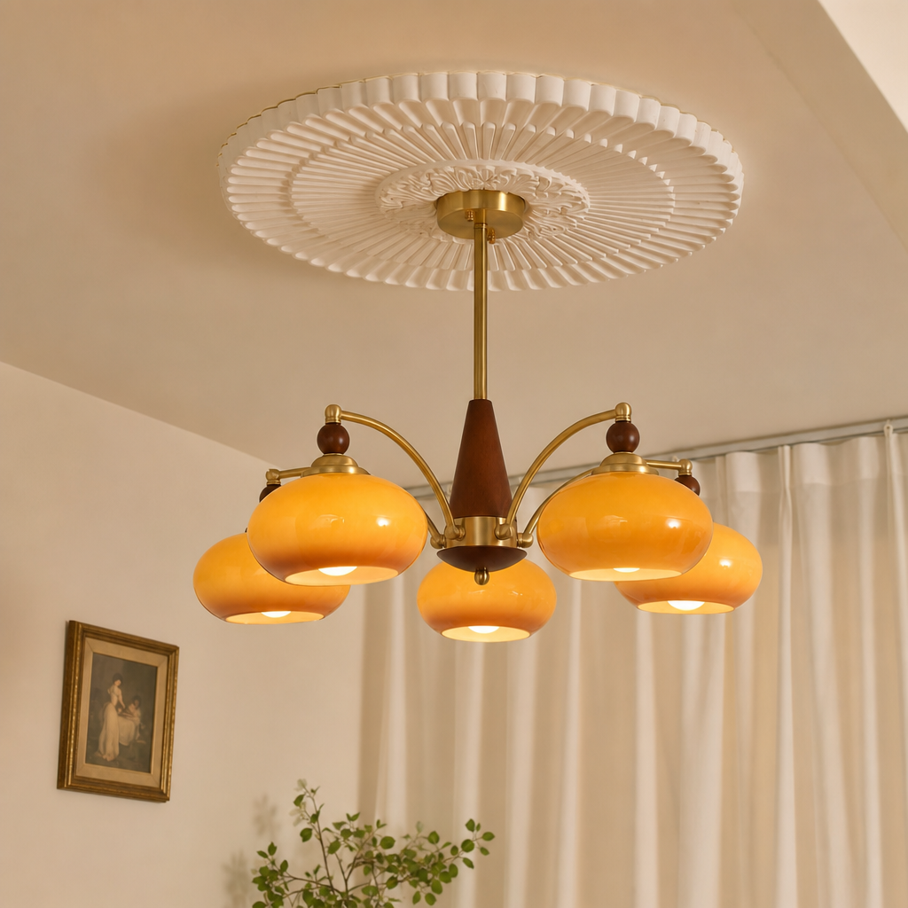 Five-light chandelier with amber glass shades, brass arms, wood accents, and a white ceiling medallion.