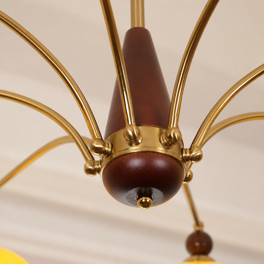 Brass and dark wood chandelier hub with curved gold arms and round finials.