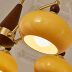 Glossy yellow and brown multi-head ceiling light with gold arms and glowing shades.