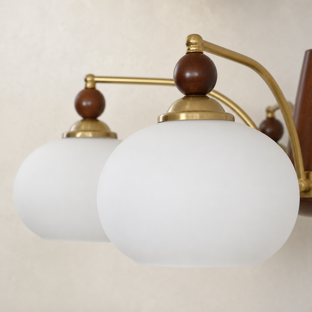 Frosted white globe light fixture with brass arms and brown wooden accents