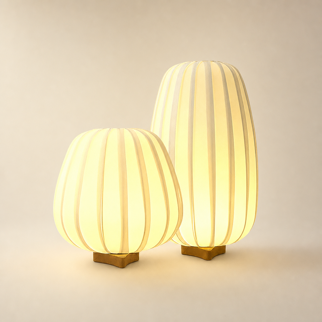 Two glowing ribbed fabric table lamps with wooden bases on a light background.