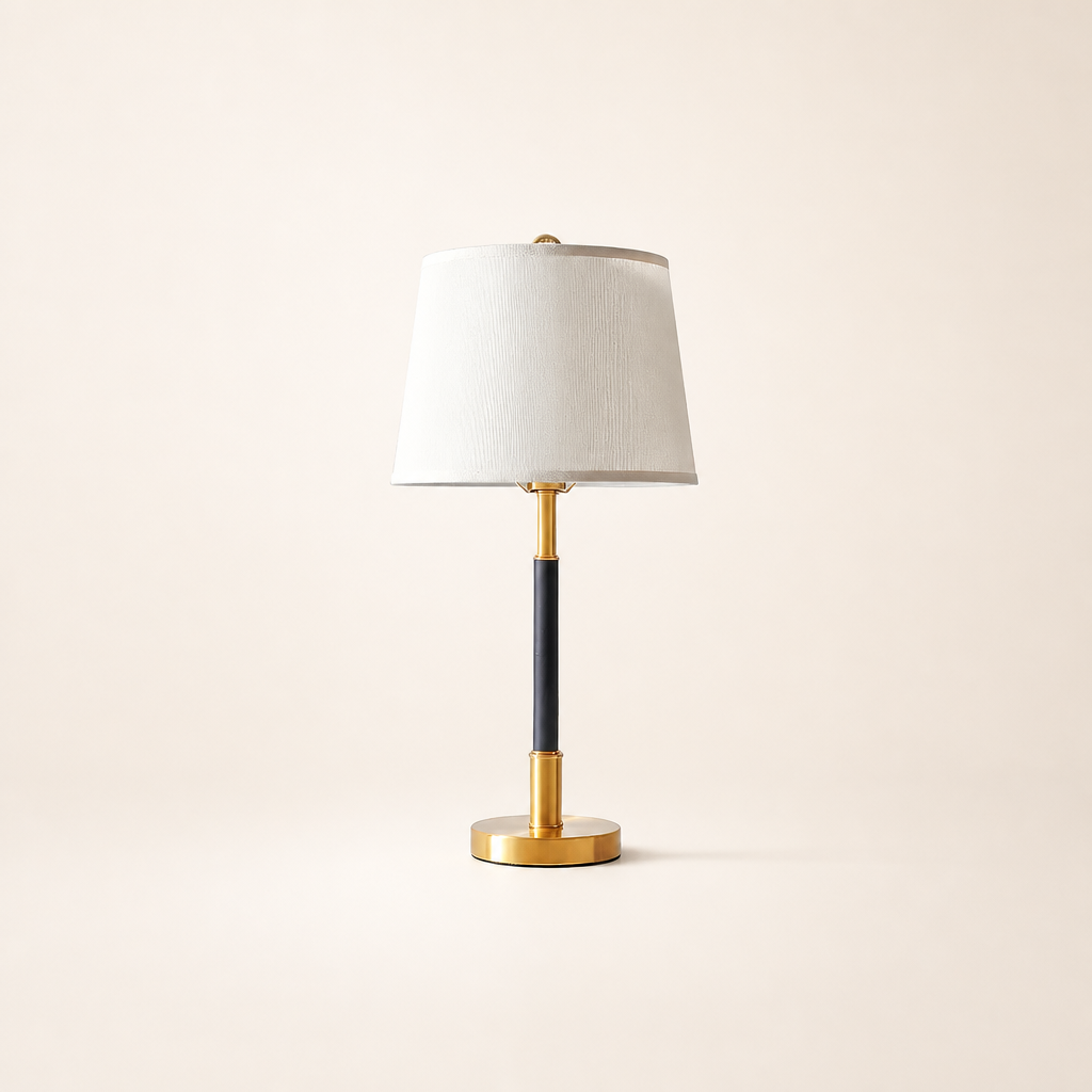 White shade table lamp with a black stem and polished gold base.