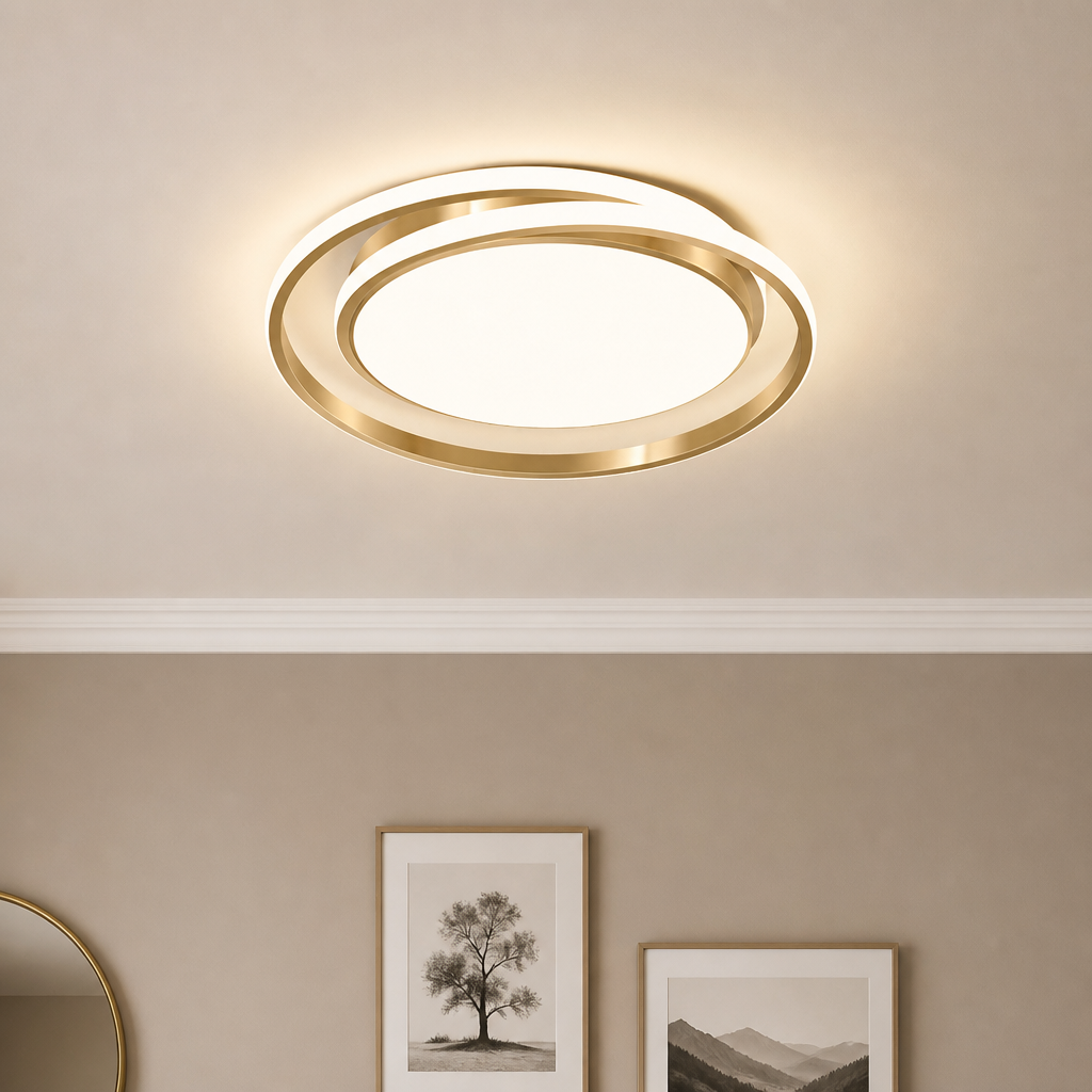 Gold ring ceiling light glowing warmly above framed wall art in a neutral room.