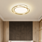 Gold circular ceiling light glowing above a modern room with wood and dark wall panels.