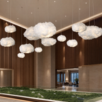 Glowing white cloud pendant lights suspended in a modern interior atrium.