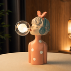 Girl figurine lamp with headphones and a glowing bubble on a warm tabletop.