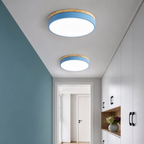 Two round blue and wood flush ceiling lights illuminating a modern hallway with cabinets.