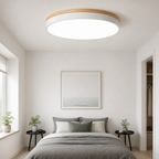Round ceiling light with wood trim above a minimalist bedroom bed and nightstands.
