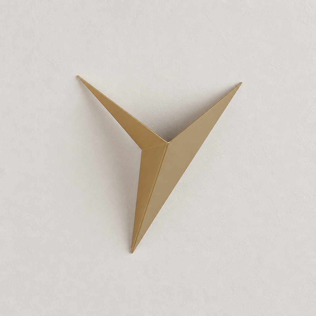 Gold angular origami bird wall decor centered on a pale textured wall.