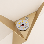 Gold triangular lamp fixture with circular LED board and wiring visible.