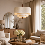 Tiered cream fabric pendant light with a wooden stem hanging in a warm neutral living room.