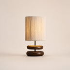 Table lamp with a beige textured shade and rounded dark wood double base.