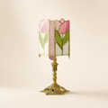 Pink tulip stained glass table lamp with ornate gold base on a pale neutral background.