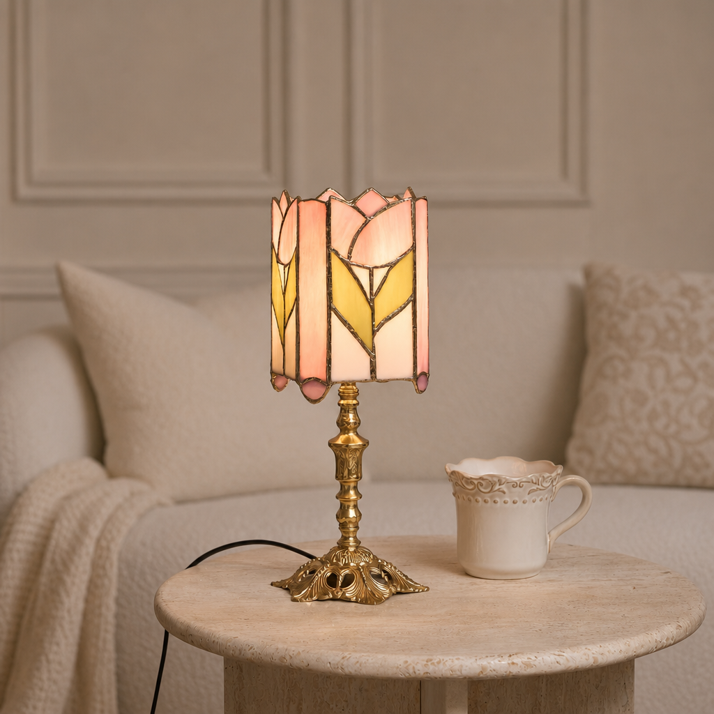 Tulip stained glass table lamp with ornate brass base on a round stone table.