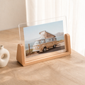 Wooden acrylic photo frame on a tabletop displaying a camper van print.
