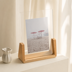 Wooden acrylic photo frame displaying a beach umbrella print on a softly lit shelf.
