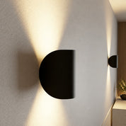 Black curved wall light with warm up-and-down lighting
