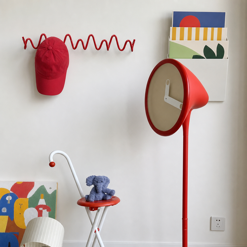 Red cone-shaped floor lamp with beige clock face in a playful room with wall decor.