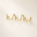 Polished gold wavy wall hook rack on a clean light background.