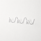 White wavy wall-mounted hook rail on a plain white textured wall.