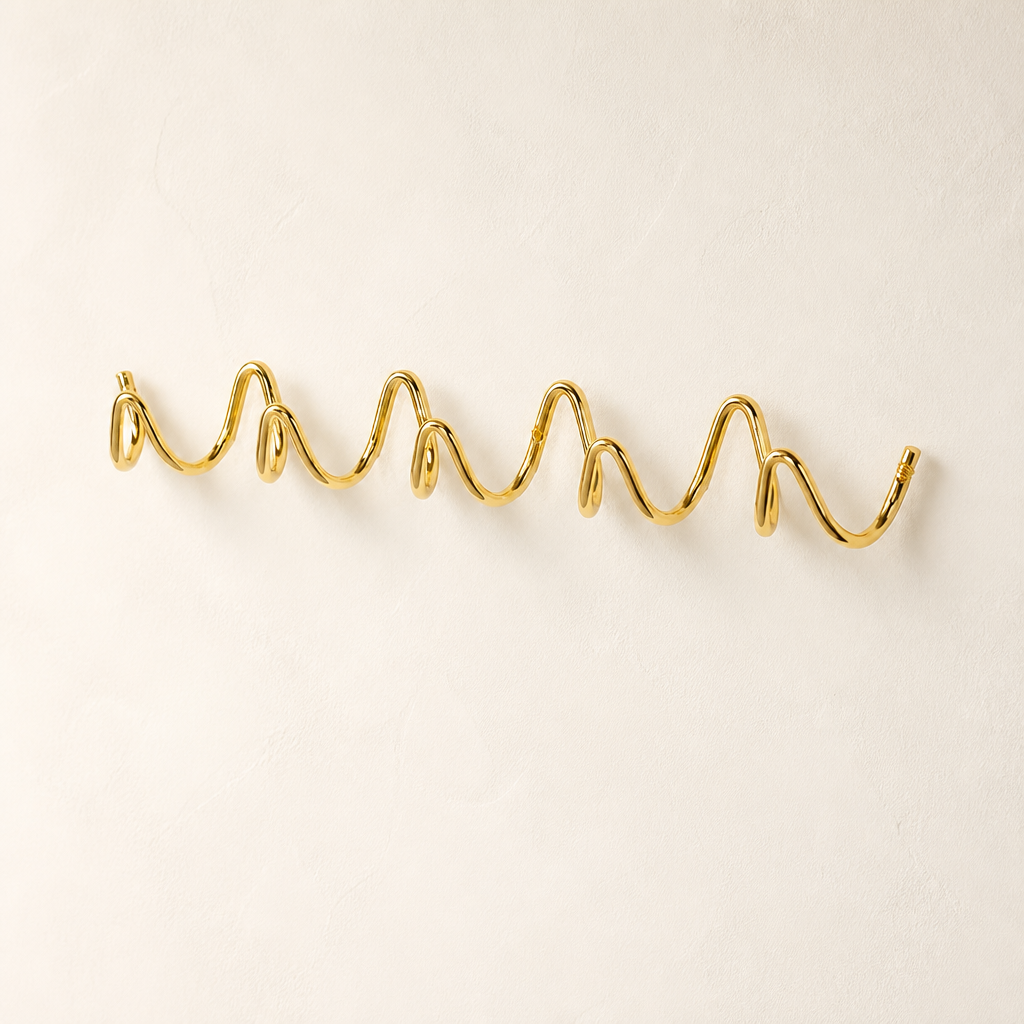 Gold wavy wall-mounted hook rack on a clean white background.
