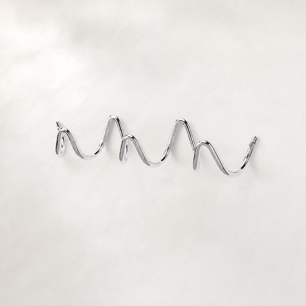 Shiny chrome wavy wall-mounted multi-hook rack on a clean light background.