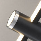 Matte black cylindrical wall light with glowing circular end and warm diagonal light bars.