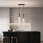 Black dual linear pendant light hanging above a minimalist kitchen island.