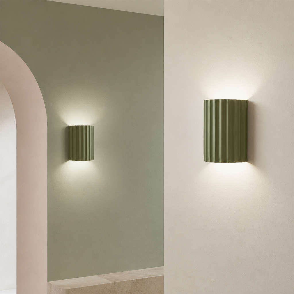 Two olive green ribbed cylindrical wall sconces casting soft up-and-down light.