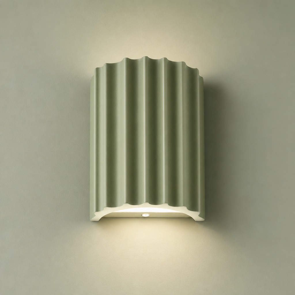 Sage green fluted wall lamp with a white base casting a soft downward glow.