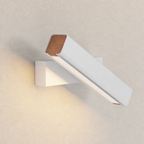 White wall-mounted linear lamp with wood accents casting warm light on a textured wall.
