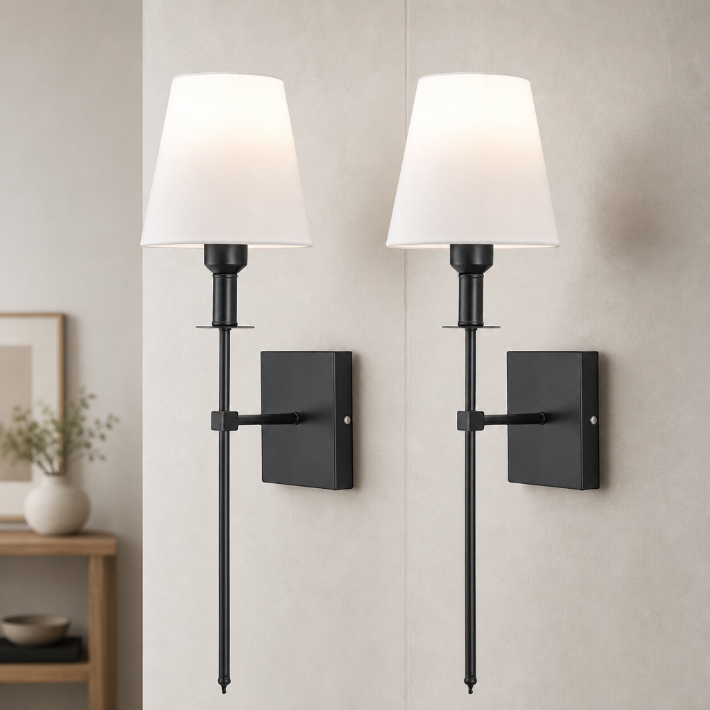 Two black wall sconces with white fabric shades mounted on a light gray wall.