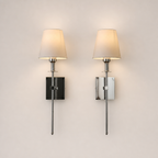 Two polished chrome wall sconces with cream fabric shades on a plain light background.