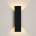 Black rectangular wall sconce casting warm light upward and downward on a plain wall.