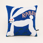 Blue square pillow with a white rabbit design and pink RABBIT lettering.
