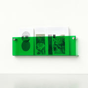 Translucent green acrylic wall magazine rack holding assorted booklets.