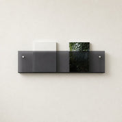 Dark translucent wall shelf holding two books on a light textured wall.