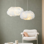 Two fluffy white cloud pendant lights glow warmly above a cozy armchair in a minimalist room.
