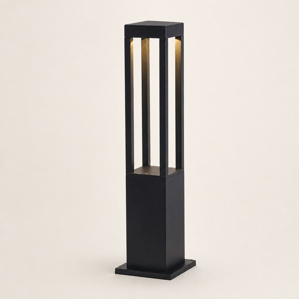 Black rectangular outdoor bollard light with warm vertical illumination on a plain light background.